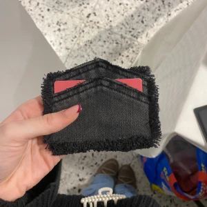 Svart jeanskorthållare med fransar - 019 - Snygg och kompakt svart korthållare i jeansmaterial med fransade kanter. Perfekt för att hålla kort och kontanter på ett stilfullt sätt. Betalning sker via swish🙌🏼