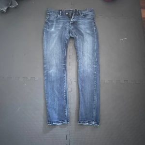 Blå jeans från Polo Ralph Lauren - Säljer ett par snygga blå jeans från Polo Ralph Lauren. De har en klassisk femficksdesign och en dragkedja med knappstängning. Jeansen har en lätt tvättad look som ger dem en cool och avslappnad stil. Perfekta för både vardag och fest!