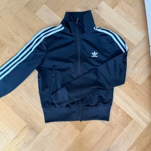 Svart adidas jacka  - En Adidas jacka som är cropped. Jag är 163 och den når ner ett par centimeter från min navel. Använd enstaka gång 