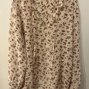 Blommig blus - En blommig bluse med bra kvalitet och lite genomskinlig som gör den väldigt stilig