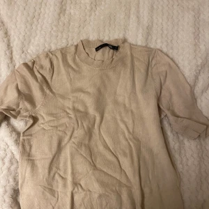 Beige tröja från 157 - Säljer en enkel och stilren beige tröja från 157. Den är kortärmad och har en rund halsringning. Perfekt för en avslappnad vardagslook. Tröjan är i bra skick och passar till det mesta i garderoben.