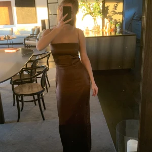 Brun långklänning i silke - Brun långklänning i silke från Refarmation. Använd en gång, är i nyskick. Org pris 4450kr, nytt pris 1999kr.