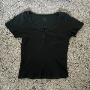 Brandy Melville topp - Snygg svart topp från Brandy Melville med korta ärmar och knappar framtill💗