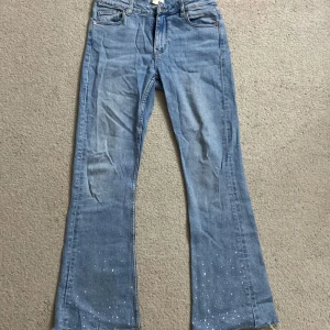 Blå jeans med paljettdetaljer från Gina Tricot - Snygga blå jeans från Gina Tricot med bootcut-stil, mycket bra skick, har använt bara några gånger💕