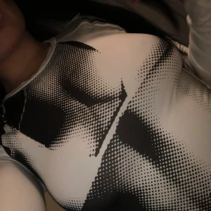 Svartvit långärmad topp  - . Perfekt för att ge en edgy touch till din outfit.