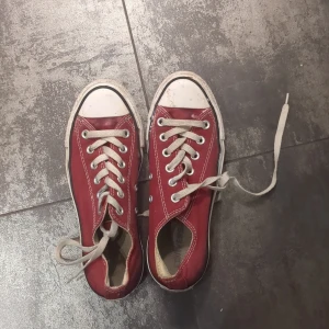 Röda sneakers med snörning - Säljer ett par klassiska röda sneakers med vita snören och tåhätta. Perfekta för sommaren och passar till många olika outfits.