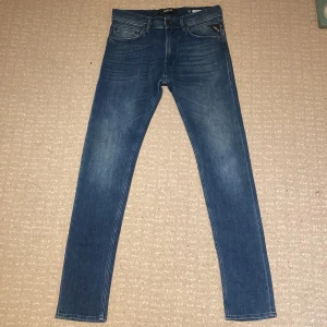 Blå jeans från Replay - Snygga blå jeans från Replay i modellen Jondrill. De är väldigt stilrena och är väldigt enkla att matcha med. Jeansen är i ett material som gör att du blir väldigt bekväm. Storleken är W31. Skick 10/10. Vid frågor och funderingar är det bara att kontakta mig! 