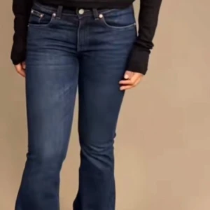 Mörkblå bootcut jeans - Snygga mörkblå bootcut jeans med låg midja och klassisk femficksdesign. Perfekta för en avslappnad men stilren look.