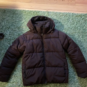Brun dunjacka med huva - Säljer en brun dunjacka med huva, från Cubus. Jackan har en dragkedja framtill, det är en dunjacka för extra värme. Den har reflexer som är helt avtagbara utan ngn skada. Perfekt till vintern nu när det blir kallt o snö ute. Det är en neutral och casual jacka. 🥶🤎Skriv vid intresse, bilder finns 