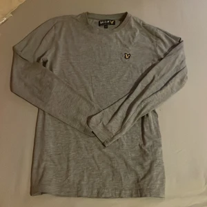 Grå långärmad tröja från Lyle & Scott - Säljer en stilren grå långärmad tröja från Lyle & Scott. Helt ny har inte andvent den 
