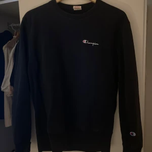 Svart sweatshirt från Champion - Säljer en klassisk svart sweatshirt från Champion med deras ikoniska logga på bröstet och ärmen. Storlek M passar även S/Xs                                            Perfekt present. 
