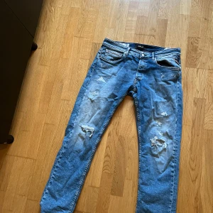 Blå jeans från Replay - Snygga blå jeans från Replay med slitna detaljer. Skick 9/10, storlek 32/32