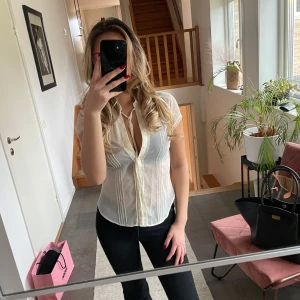 Blus - Vit/beige kortärmad blus med knappar.