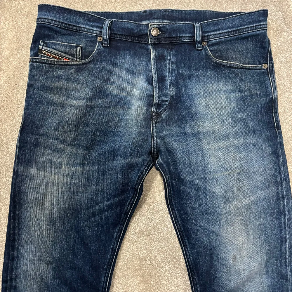 Säljer dessa riktigt snygga Diesel jeans i en snygg blå tvätt. Overall bra skick, inga slitningar eller märkvärda fläckar, finns en liten fläck på vänster knä som knappt syns. Size 34 passar typ 180-187. Skriv vid funderingar!. Jeans & Byxor.