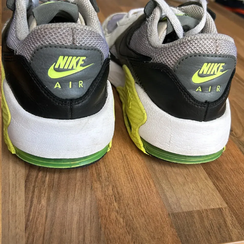 Säljer ett par Nike Air Max sneakers i grått och neongult. De har en cool design med svarta detaljer och den klassiska Air Max-sulan. Perfekta för både träning och vardagsbruk. Skorna har snörning och är i bra skick.. Skor.