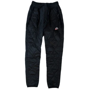 Nike Byxor - "Nike NSW Heritage Winterized Trousers" storlek XS. Använda med en defekt på vänster ben. 