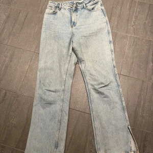 Blåa jeans med slits  - Säljer dom här jeansen från NA-KD då dom är förstora för mig. 