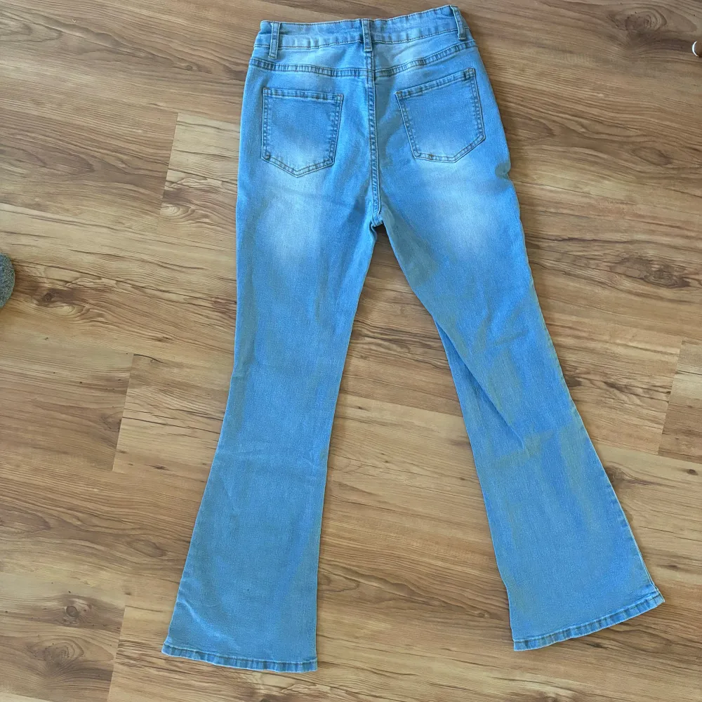 Säljer ett par ljusblå bootcut/flared jeans i bra skick. De är perfekta för både vardag och fest. Jeansen har en snygg utsvängd stil. De har blivit använda max två gånger!. Jeans & Byxor.