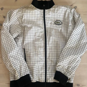 Lacoste Jacka - Passar M, bra kondition o fin jacka till vår. Rätt tunn och håller sig bra i regn. 