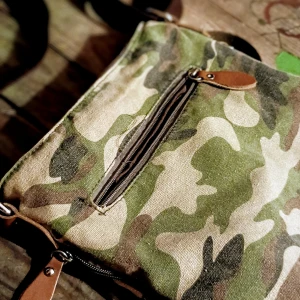 Camouflagefärgad axelväska med dragkedja - Säljer en cool axelväska i camouflagefärger. Väskan har en praktisk dragkedja och justerbar axelrem i brunt tyg. Perfekt för vardagsbruk eller när du vill ha en avslappnad stil. Den är rymlig och har flera fack för enkel organisering.