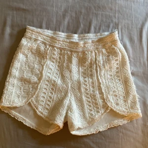 Vita spets shorts - Snygga vita shorts i spets med vackra detaljer. Perfekta för en somrig look med sin luftiga och eleganta design. De har en bekväm passform och är idealiska för varma dagar. Passar xs och s. Det finns en liten ”skada” på byxorna (bild 3) annars är de i bra skick!💓