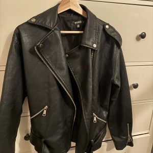 Svart skinnjacka - Snygg svart skinnjacka från Missguided köpt på Nelly.com med bälte som är avtagbart. Storlek 36 och lite oversized i modellen💌