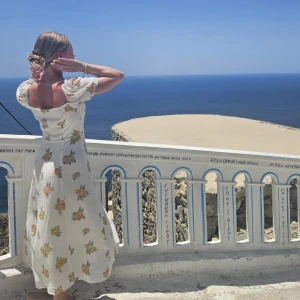 Klänning med slits - Vit klänning med blommigt mönster och en slits framtill. Endast använd enstaka gånger så i princip nytt skick.