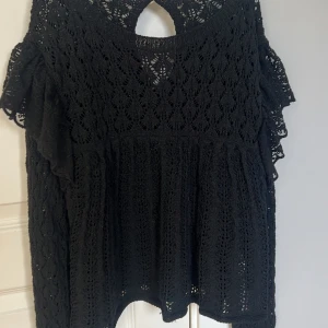 Svart spetsblus från Zara - Säljer en elegant svart spetsblus från Zara. Blusen är långärmad  och ett vackert spetsmönster. Perfekt för att klä upp en outfit med sin stilrena design. Är i storlek S men känns som en XS