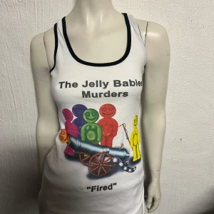 Vit linne med tryck - Säljer ett vitt linne med ett färgglatt och humoristiskt tryck av Jelly Babies och texten 'The Jelly Babies Murders - Fired'. Linnet har svarta kanter vid ärmhål och halsringning.