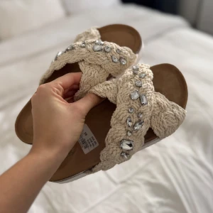 Beige sandaler med pärlor - Snygga beige sandaler med flätad design och glittrande pärlor. Använda en gång, prislapp kvar. Passar även 38. Köpt för 450kr