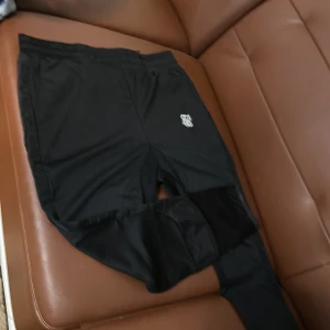 Svarta mjukisbyxor från SikSilk - Snygga svarta mjukisbyxor från SikSilk med elastisk midja och logotyp på benet. Perfekta för en avslappnad stil. Tillverkade i ett mjukt och bekvämt material.