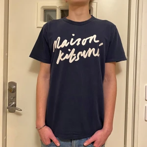 Maison Kitsuné  t-shirt - Säljer en mörkblå t-shirt från Maison Kitsuné. Den är i fint skick och har inga defekter. Killen på bilden är 180. Hör av er vid frågor☺️