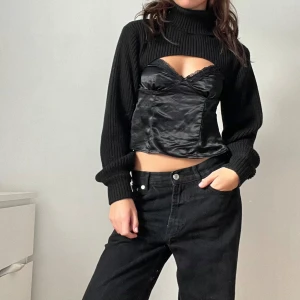 Svart ribbad bolerotopp - Trendig svart ribbad bolerotopp med polokrage och långa ärmar. Perfekt för lager-på-lager-stil. Storlek M men jag på bilden bär vanligtvis xs.