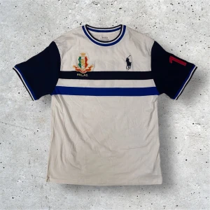 Ralph Lauren T-Shirt - Säljer denna fräscha raffe t-shirten som har en design som liknar en fotbollströja. Tröjan är i barnstorlek men passar S och lite uppåt. Skicket på tröjan är 9/10 och har inga defekter. Pris kan diskuteras!