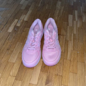 Rosa sneakers med snörning - Säljer ett par snygga rosa sneakers i storlek dam 38. Skorna har en sportig design med snörning och en bekväm sula. Perfekta för en casual look.