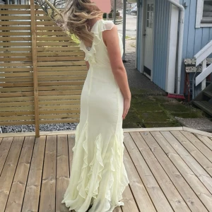 Ljusgul balklänning med volangdetaljer - HELT SLUTSÅLD OANVÄND MED LAPP KVAR! Säljer min perfekta ljusgula balklänning med volangdetaljer och v-ringad design. Klänningen är oanvänd/HELT NY och har originalpåse och LAPPAR KVAR. Säljer för att jag missade returdatumet🌸🎀 Storlek 36 och perfekt i längd. Jag säljer för 1299kr, kan diskutera priset vid snabb affär, Nypris är 1569kr  