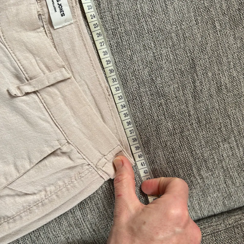 Snygga beige byxor från Jack & Jones med en stilren design. Byxorna har en normal passform och är tillverkade i en blandning av bomull, linne och elastan för extra komfort. Perfekta för en avslappnad men ändå uppklädd look.. Farkut & Housut.