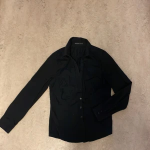 Svart skjorta med knappar  - Säljer en skjorta från Atmosphere i storlek 36. Den har krage upptill samt knappar både framtill och på ärmarna. ⭐️