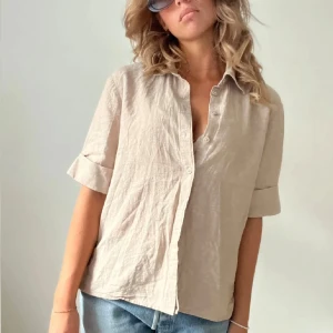 Beige linneskjorta / blus - Snygg beige skjorta i linne med korta ärmar från ginatricot. Aldrig använd endast testad.