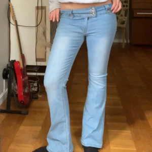 Ljusblå bootcut jeans - Snygga ljusblå bootcut jeans med låg midja. Supercoola detaljer fram och baktill. Midjemåttet är ca 38cm och Innerbenslängden är ca 77cm. Jättebra skick❤️
