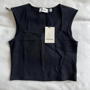 Svart linnetopp från Vero Moda  - Snygg svart linnetopp från Mathilde Gøhler för Vero Moda. Toppen har en stilren design med breda axelband och en fyrkantig halsringning. Perfekt för att matcha med olika outfits.