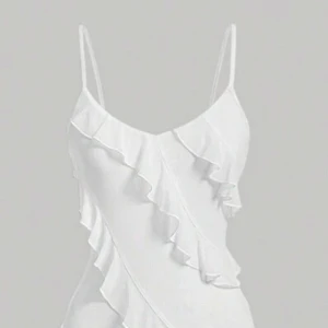 Vit klänning med volanger - Säljer en elegant vit klänning med smala axelband och v-ringning. Klänningen har vackra volangdetaljer som löper diagonalt över hela plagget, vilket ger en romantisk känsla. Perfekt för sommarens alla tillfällen!