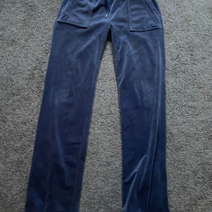 Blå juicy byxor - Intressekoll på mina blå juicy byxor! Kan tänka mig sälja för runt 800, i mycket fint skick förutom att en metall sak har ramlat av ( se bild 3 ) och därav priset!