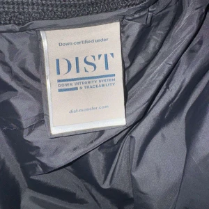 Svart dunväst från Moncler - Snygg svart dunväst från Moncler med dragkedja och huva. Västen har en quiltad design och praktiska fickor med knappar. Perfekt för kyligare dagar.