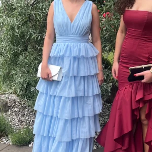 Ljusblå långklänning med volanger - Hej, jag säljer min systers eleganta balklänning som hon hade på sin studentbal. Den är från bubbleroom och är endast använd en gång samt saknar deffekter utöver sista bilden vilket inte syns vid användning. Klänningen går dessutom att tvätta som vanligt! Tveka inte att höra av dig med frågor🌸😻