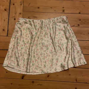 Blommig kjol Gina  - Blommig kjol från Gina. Helt ny med lappen kvar. Storlek 38 men stretchig i midjan