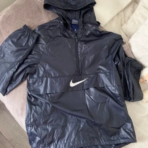 Regnjacka Nike  - Rwgnjacka från Nike i mörkblå färg. Xs passar även s. 