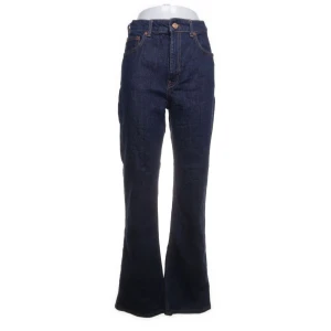 Mörkblå bootcut jeans - Säljer ett par snygga mörkblå bootcut jeans. De är högmidjade och har en klassisk femficksdesign med knapp och dragkedja framtill. Perfekta för både vardag och fest!