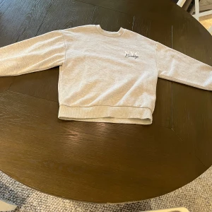 Tröja - Grå tröja med tryck på ryggen.