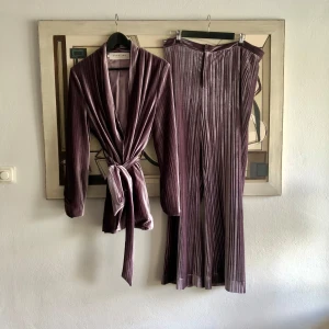 By Malina lila sammets kostym  - En superfin kostym i lila sammet i från By Malina. Strl XL på båda. Tycker dock kavajen kan bäras av flera strl då den är omlott med skärp. Byxorna endast av XL 